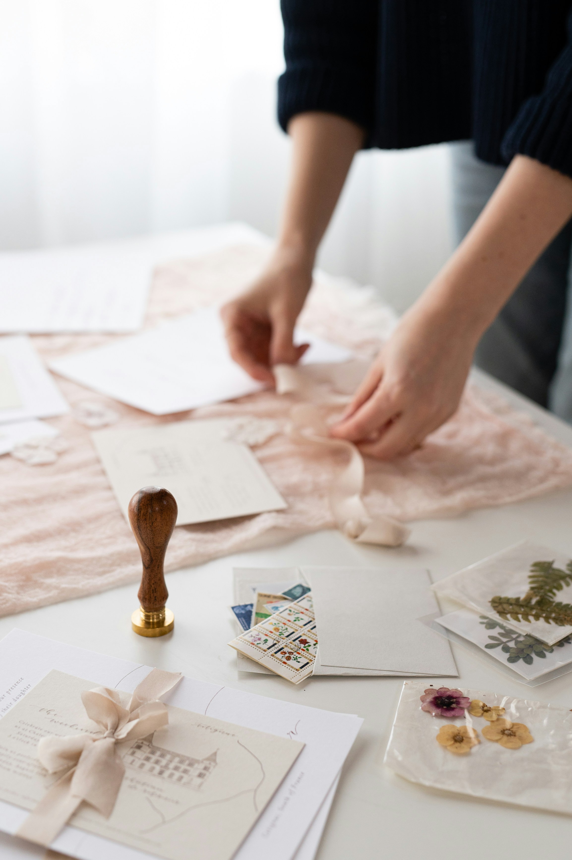 Hand-tying a silk ribbon on stationery